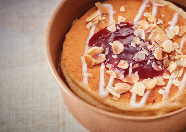 Pot of pancakes covered in almonds and a strawberry sauce - sweet bakery products