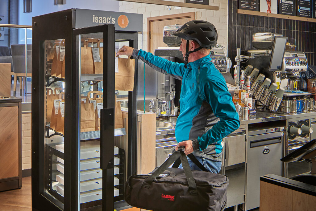 Delivery driver removing packaged food orders from a Flexeserve Hub hot-holding unit located front-of-house